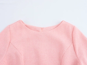 Close-up of pink tweed dress round neckline showing fabric texture and invisible zipper