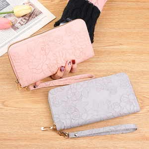 Women's long zip-around floral embossed clutch wallet in pink and grey with wristlet