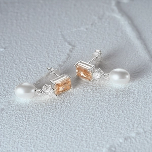 Detail of s925 silver pearl earrings with champagne gemstones and dangling white pearls