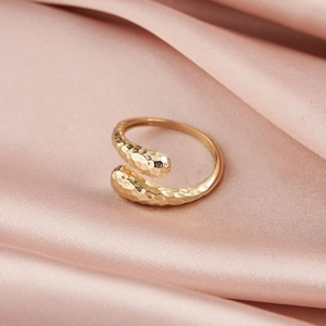Macro shot of S925 sterling silver ring with hammered texture on pink silk background