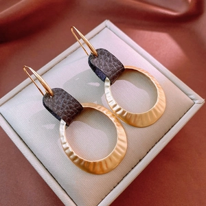 Vintage gold geometric hoop earrings with faux leather accents in a minimalist design