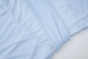 Detailed close-up of light blue mesh fabric with elegant ruching and stitching detail