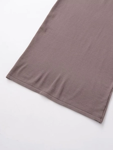 Detailed close-up of brown knit fabric texture and hem stitching on a midi skirt