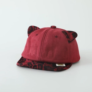 Détail de la casquette enfant en faux suède rouge avec oreilles de chat léopard