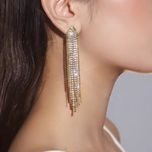 Macro side view of long tassel earrings with sparkling rhinestones and gold plating
