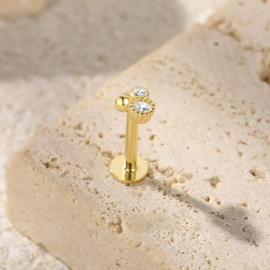 Detail of a gold S925 sterling silver butterfly piercing earring with clear zircons