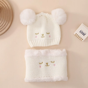 Detail of baby winter knit hat and scarf set with cute animal embroidery and pom-poms