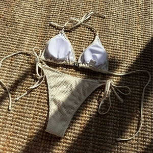 Detail of solid color bikini set with unique textured fabric and washing label on mat