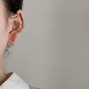 Detailed close-up of a minimalist gold infinity ear cuff set worn on a model