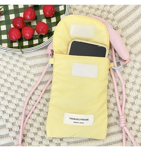 Detail of yellow fabric phone pouch with pink drawstring strap and velcro closure