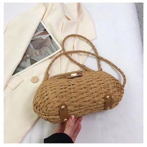 Dettaglio borsa da spiaggia intrecciata con fibbia magnetica e base in pelle con borchie