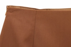 Gros plan détaillé du tissu sergé marron camel avec fermeture éclair invisible sur la jupe
