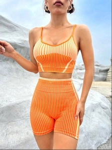 Dettaglio del set yoga in maglia a coste arancione con crop top e pantaloncini a vita alta