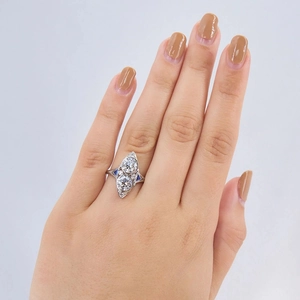 Vertical double-stone silver ring with clear and blue sapphires on hand