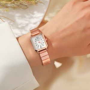 Makroaufnahme einer roségoldenen rechteckigen Uhr mit Metallarmband am Handgelenk