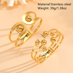 Polished gold stainless steel cuff bracelets with hollow design and metal ball accents