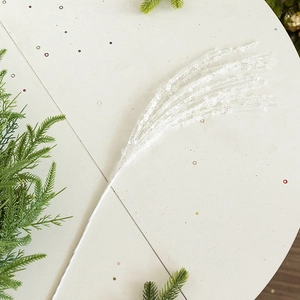 Detail view of white sequined Christmas branch decoration with glitter on light background