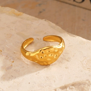 18K gold plated hammered texture stainless steel open ring on a stone pedestal