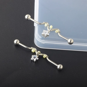 Detail of silver industrial barbell with star-shaped zircon pendant and yellow beads