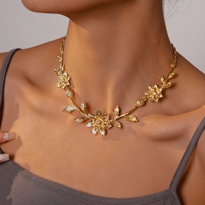 Macro view of golden flower necklace with intricate metal textures and sparkling crystals