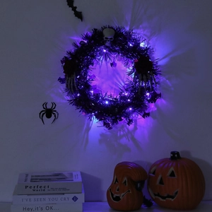 Detail of glowing Halloween wreath with purple LED lights, skull, and black roses
