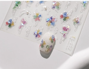 Macro shot of 3D embossed watercolor floral nail stickers with small pearl accents