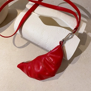 Detail einer roten Horn-Geldbörse aus Kunstleder mit silbernem Clip und Trageriemen
