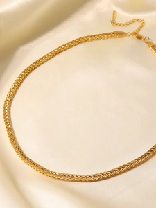 Dettaglio della collana a maglia intrecciata dorata su seta con finitura oro 18K