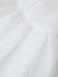 Close-up detail of white pleated fabric texture and stitching on sexy backless mini dress