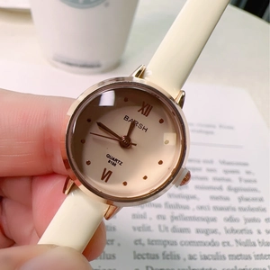 Close-up of elegant small dial quartz watch with beige strap and rose gold case