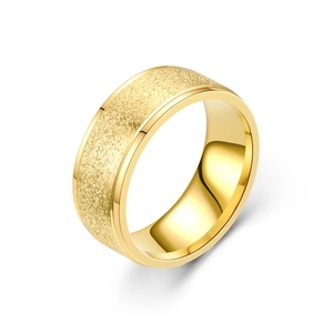Détail d'une bague en acier doré avec surface sablée et bords polis à double niveaux