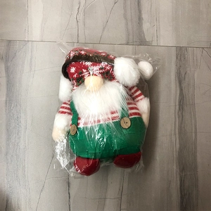 Dettaglio dello gnomo natalizio in peluche lavorato a maglia con abito rosso e verde