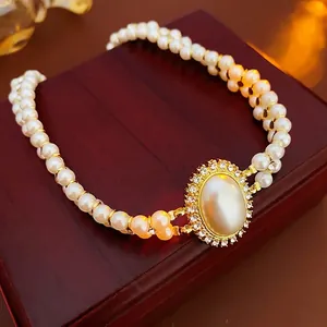 French vintage double-layered pearl necklace with crystal oval pendant on wooden stand