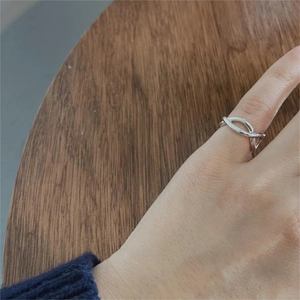Close-up of minimalist 925 sterling silver ring with interlocking design on finger