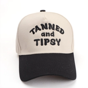Detail of TANNED and TIPSY 3D embroidery on two-tone beige and black cotton baseball cap