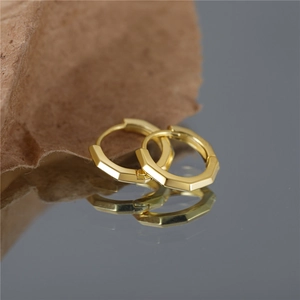 Classic gold geometric octagonal silver hoop earrings on a dark reflective background