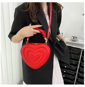 Detail of red heart-shaped shoulder bag with tiered texture and ruched handle