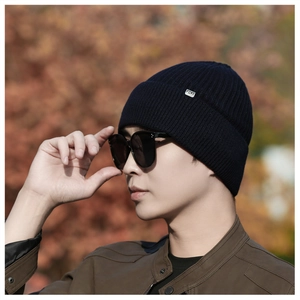 Detail of navy knit beanie with ribbed texture and side logo tag for winter warmth