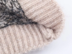 Detailed macro view of the fluffy mohair knit texture in beige and dark grey colors