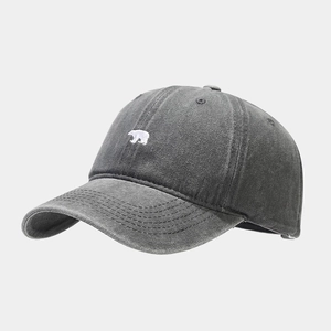 Close-up of polar bear embroidery on washed dark grey cotton baseball cap