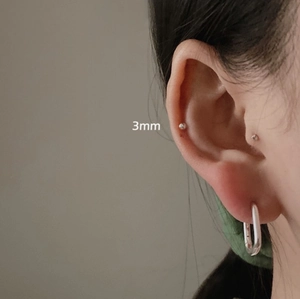 Detail of 925 sterling silver 3mm bead stud and hoop earrings on model's ear