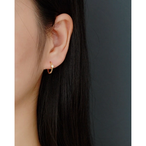 Close-up of S925 silver gold-plated hoop earring with crystal and beaded texture