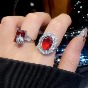 Detailed view of silver rings featuring large red rubies and intricate diamond accents