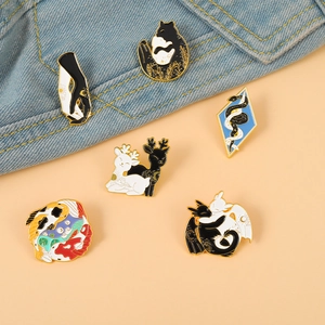Détail de broches émaillées représentant des dragons et carpes koï sur du tissu en denim