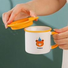 Close-up of a white ceramic mug with yellow lid featuring a cute cartoon tiger and happy text