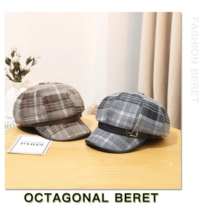 Detail of wool plaid newsboy caps with leather brim in brown and grey patterns
