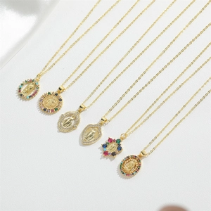 Close-up of gold necklaces with colorful zircon religious pendants on white silk