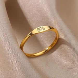 Polierter Goldring mit 999er-Gravur auf einem minimalistischen Band aus Edelstahl