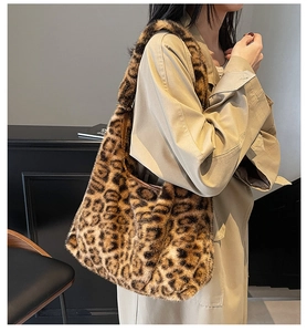 Macro shot of large faux fur leopard print tote bag with soft plush texture on beige coat