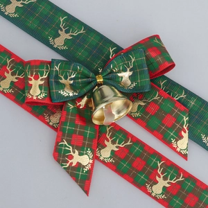 Christmas ribbon with gold reindeer print, green plaid bow, and golden festive bell detail